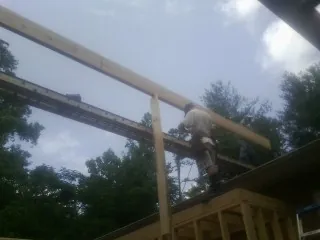 Carpenter setting a ridge beam over a new addition frame — Ice Dam Removal by Roofing Brothers in New Prague