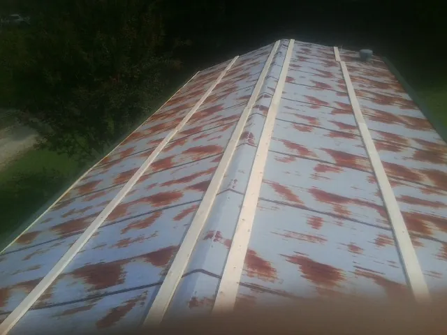 Rusted metal roof panels with new wood purlins before replacement — Storm Damage Roof Repair in New Prague by Roofing Brothers